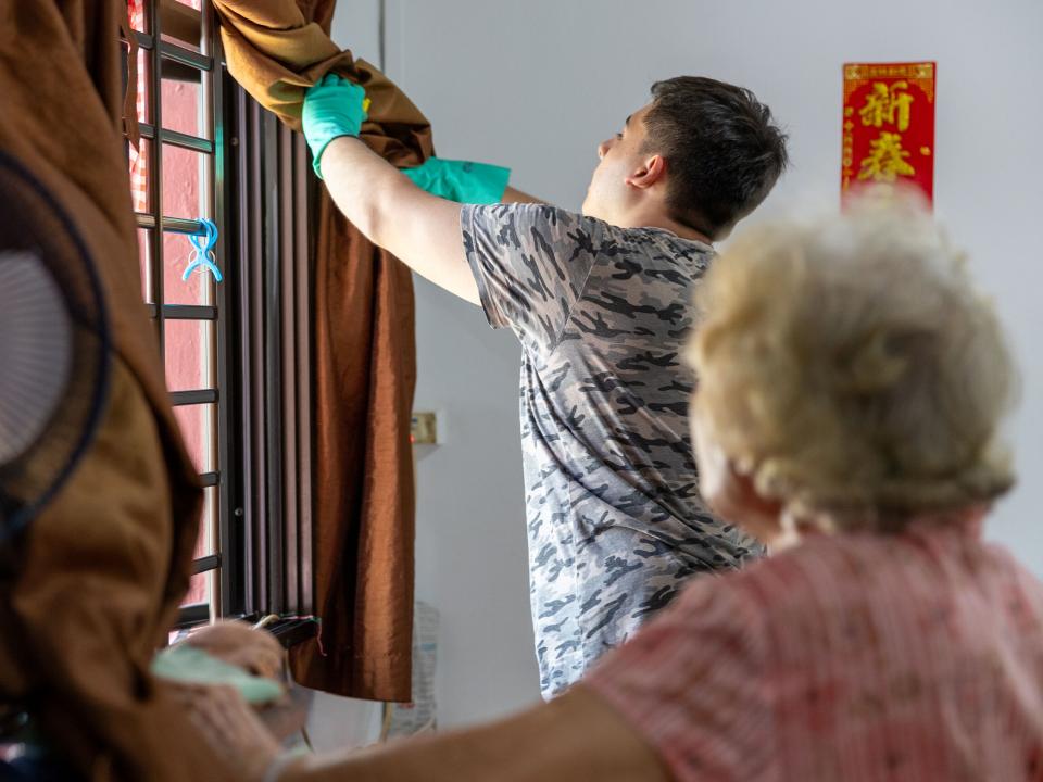 Singapore, Singapore :: A crewmember helps clean the home of an elderly lady